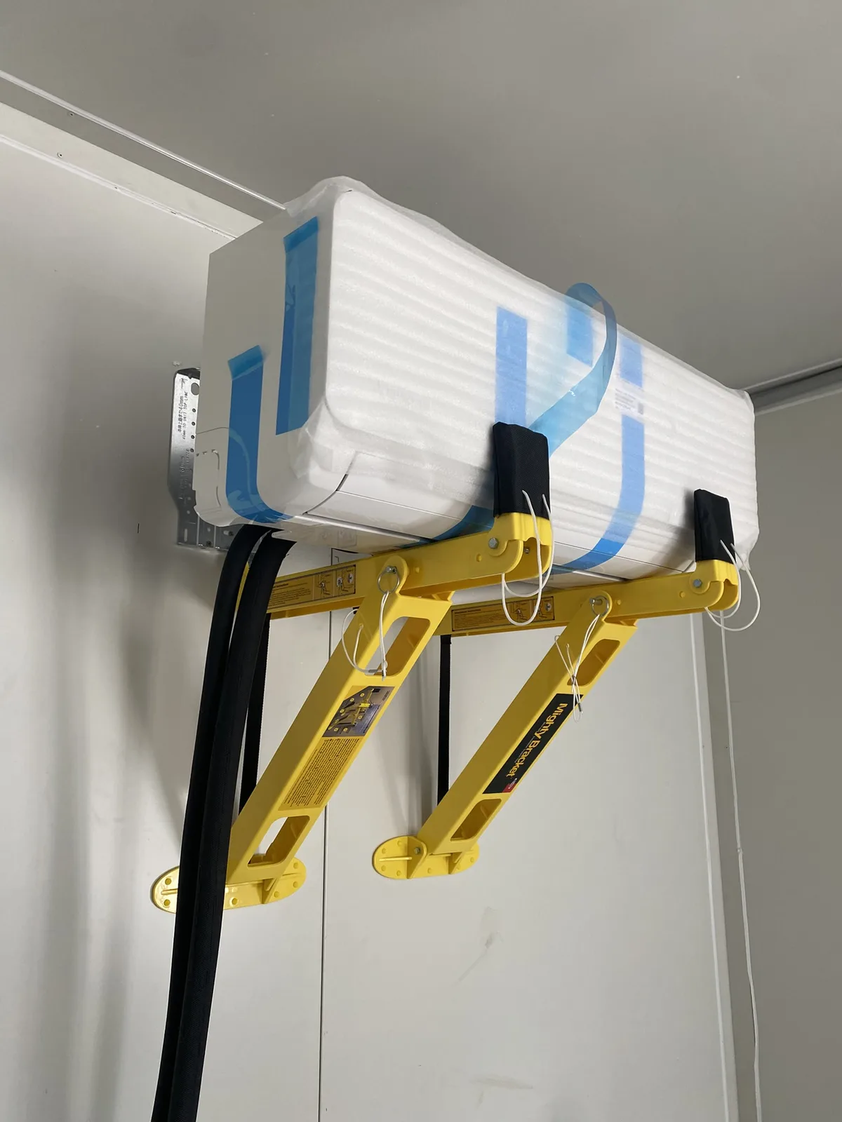 Outdoor unit on wall brackets, pipes ducted