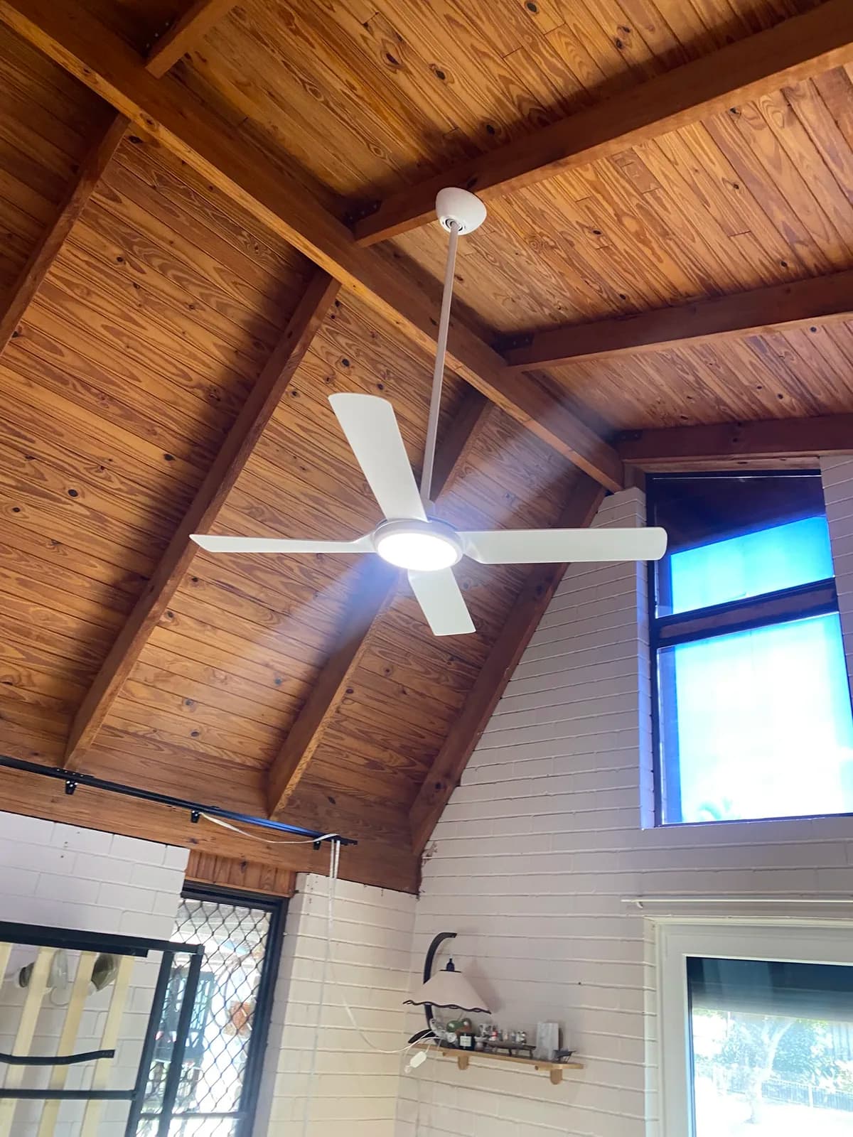 White ceiling fan on a raked timber ceiling