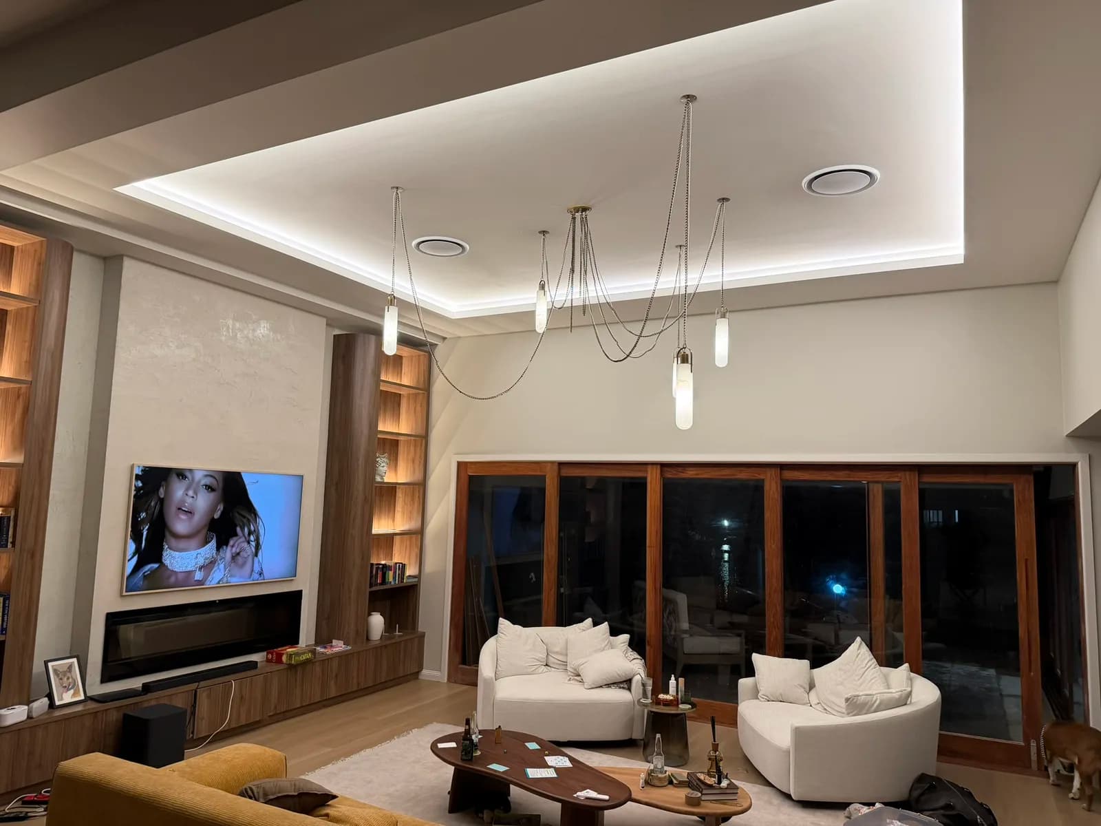 Open-plan living room with LED downlights, cove lighting and pendants